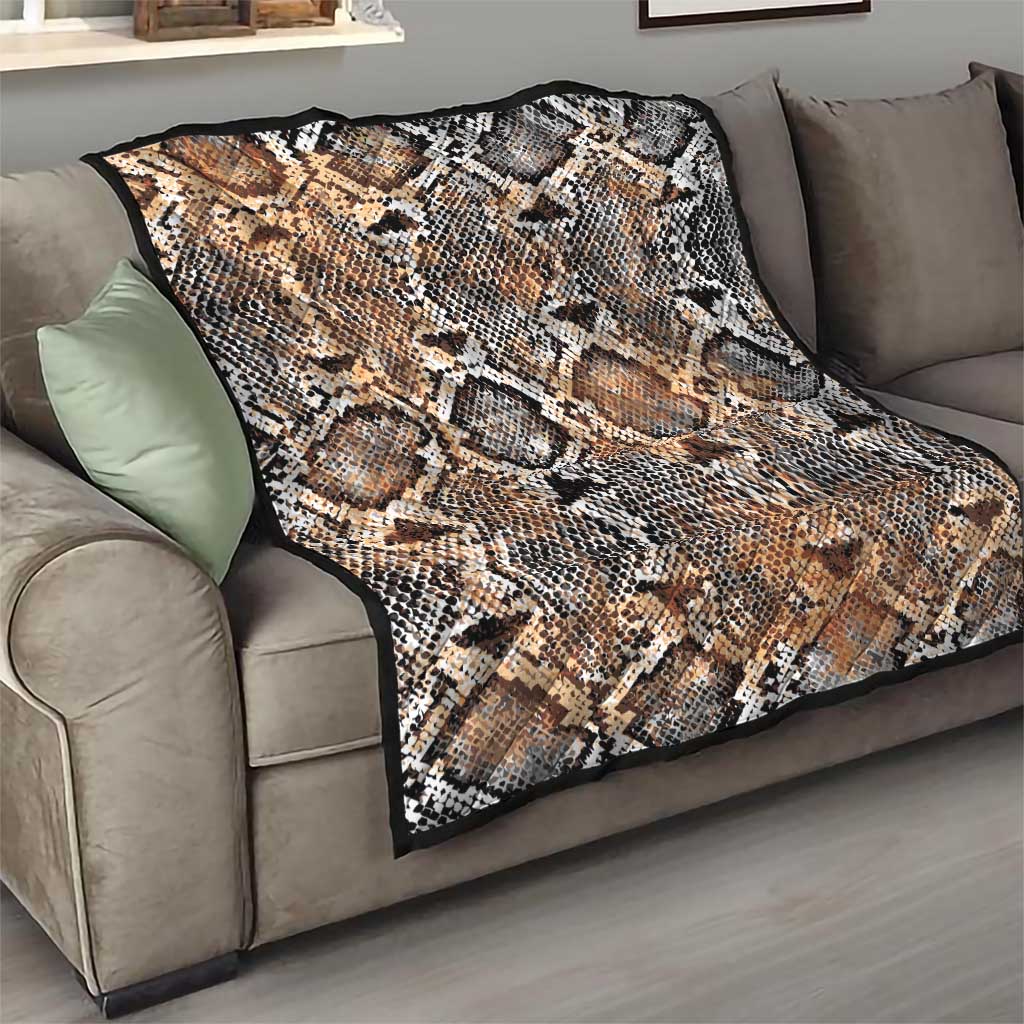 Snake-skin patterned quilt on sofa, beige tan with black and white diamond scales