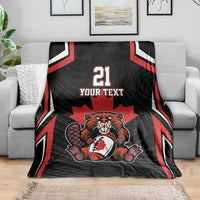 Black Canada rugby blanket draped over sofa with red stripes, beaver and maple leaf, 21