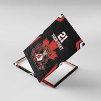 Black canvas wall art with red maple leaf and beaver mascot, angled view