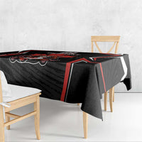 Black tablecloth draped over dining table edge, red and white geometric border