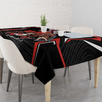Black tablecloth on dining table with red-lined graphic and bold emblem centerpiece