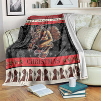 Krampus Christmas blanket draped on sofa; black fabric with red bands, demon graphic, and text