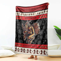 Krampus Christmas blanket shown folded on floor; black with red top stripe and demon illustration