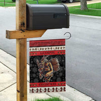 Krampus Christmas garden flag hanging on wooden post, dark with red trim and patterned border