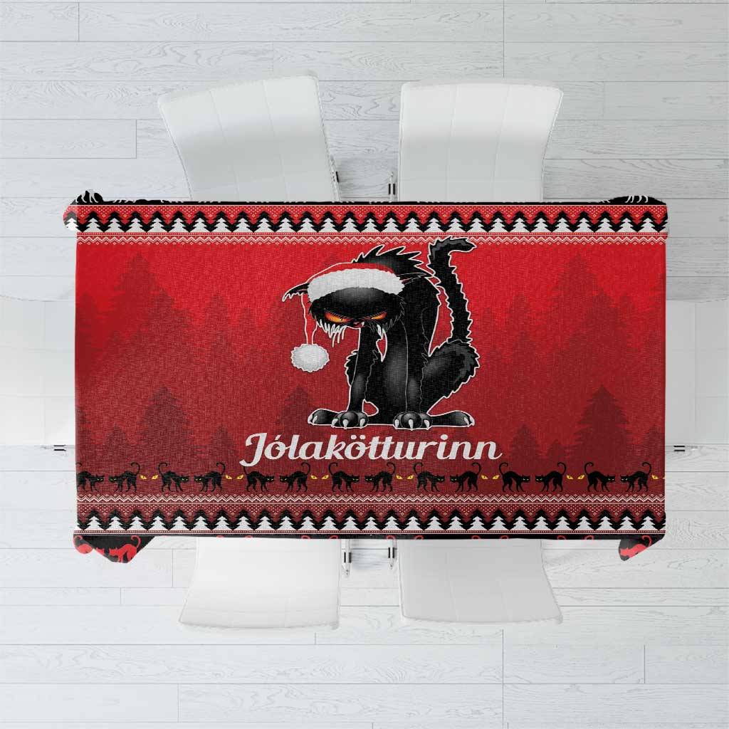 Red tablecloth with black cat graphic and winter motifs along the border