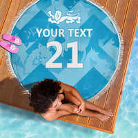Blue round beach blanket with tassel fringe, lion crest and '21' with 'YOUR TEXT', laid out.