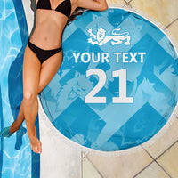 Blue round beach blanket with tassel fringe, lion crest and '21' with 'YOUR TEXT', on display.