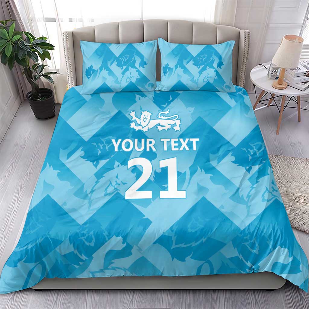 Blue bedding set with lion crest over “YOUR TEXT 21” print on duvet and pillows
