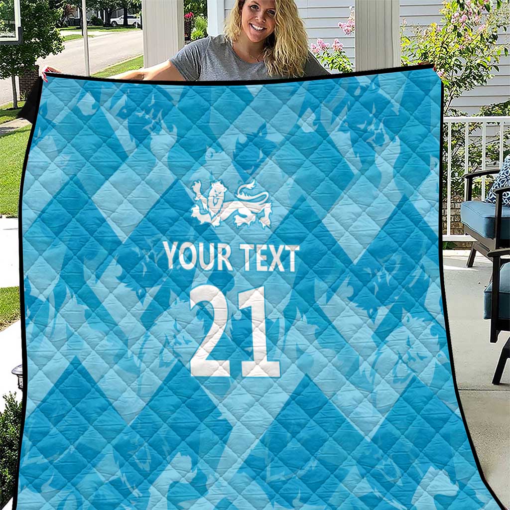 Blue quilt with diamond stitching, white crest and custom text over large “21”.