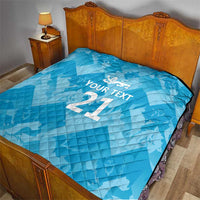 Blue quilted bedspread with white crest and custom text, showing large “21”.