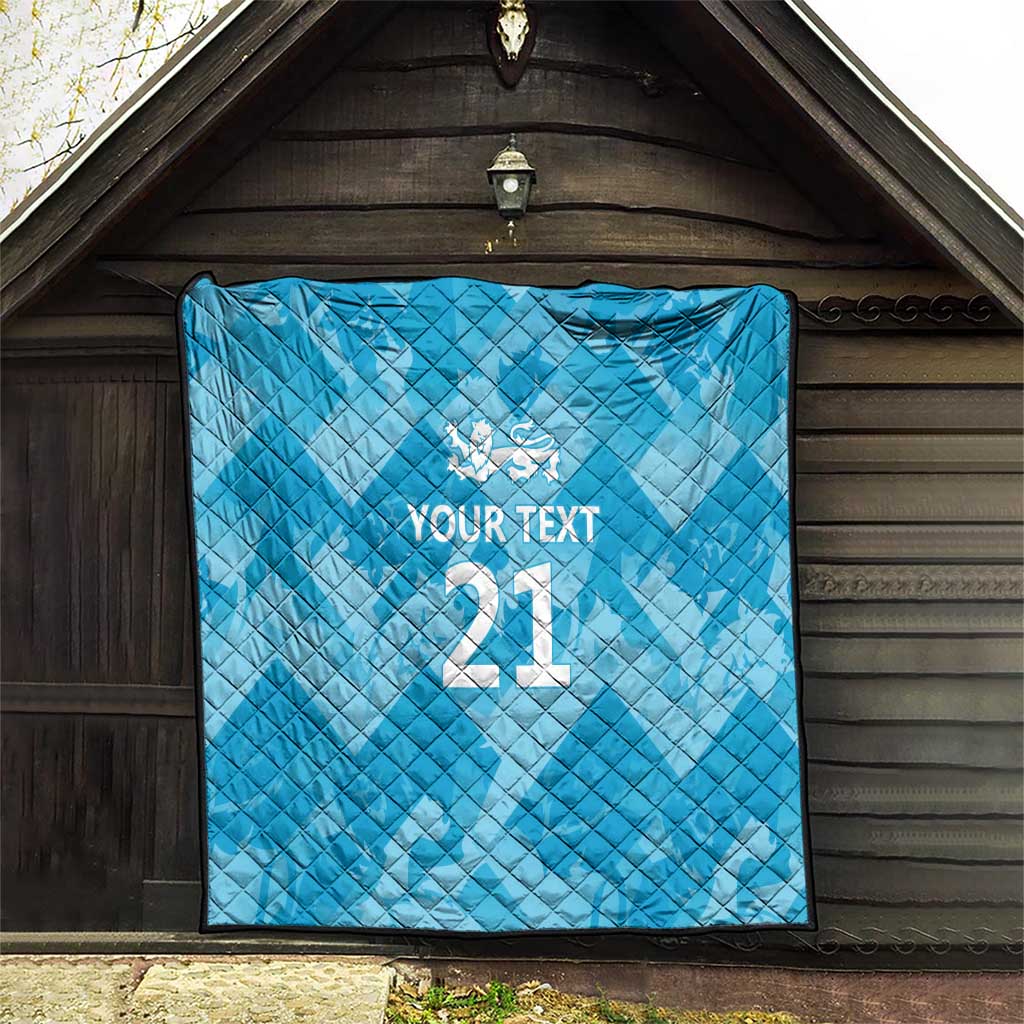 Blue quilt with diamond quilting pattern, white crest and “YOUR TEXT” above “21”.