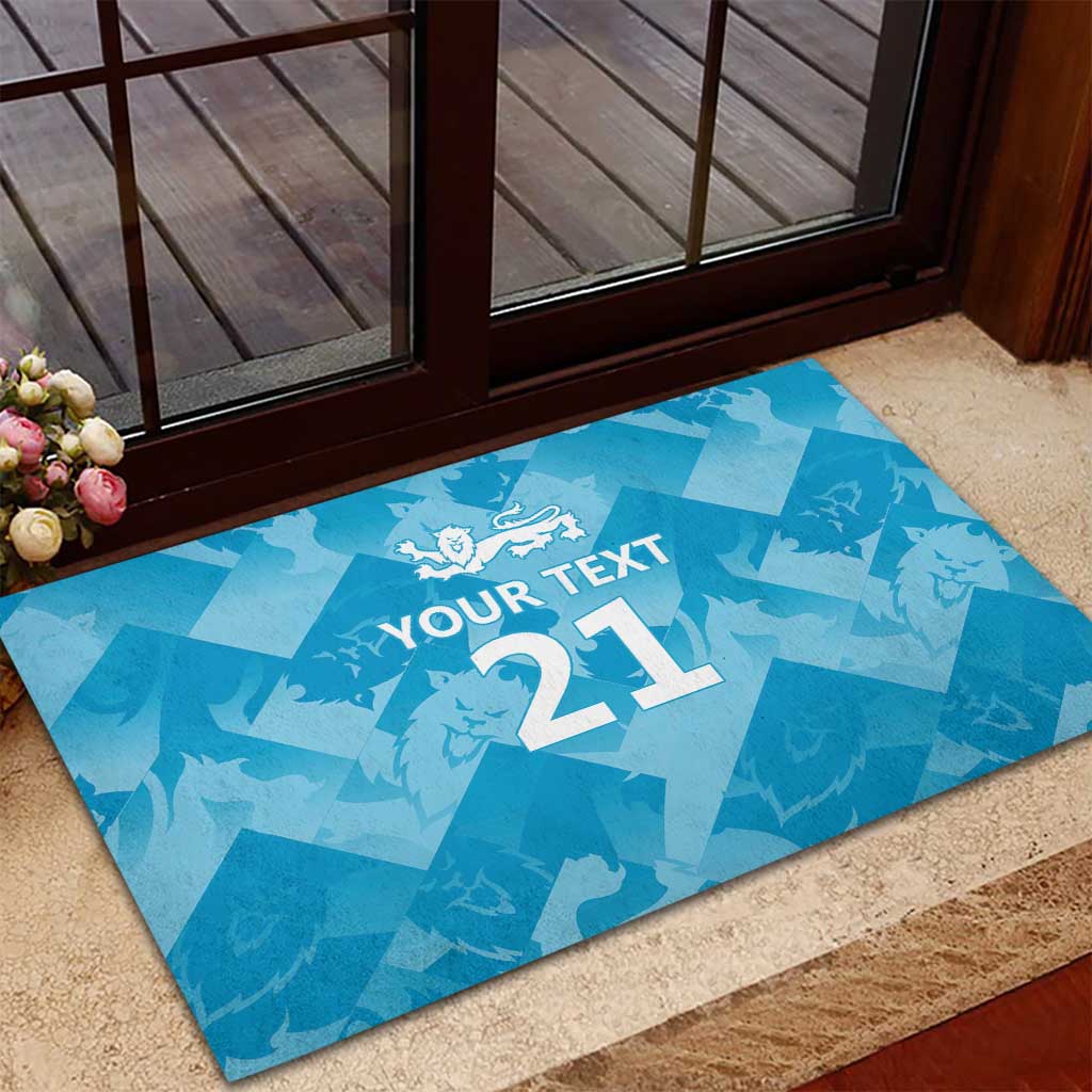Blue rubber doormat with 'YOUR TEXT 21' and lion crest placed at an entryway.