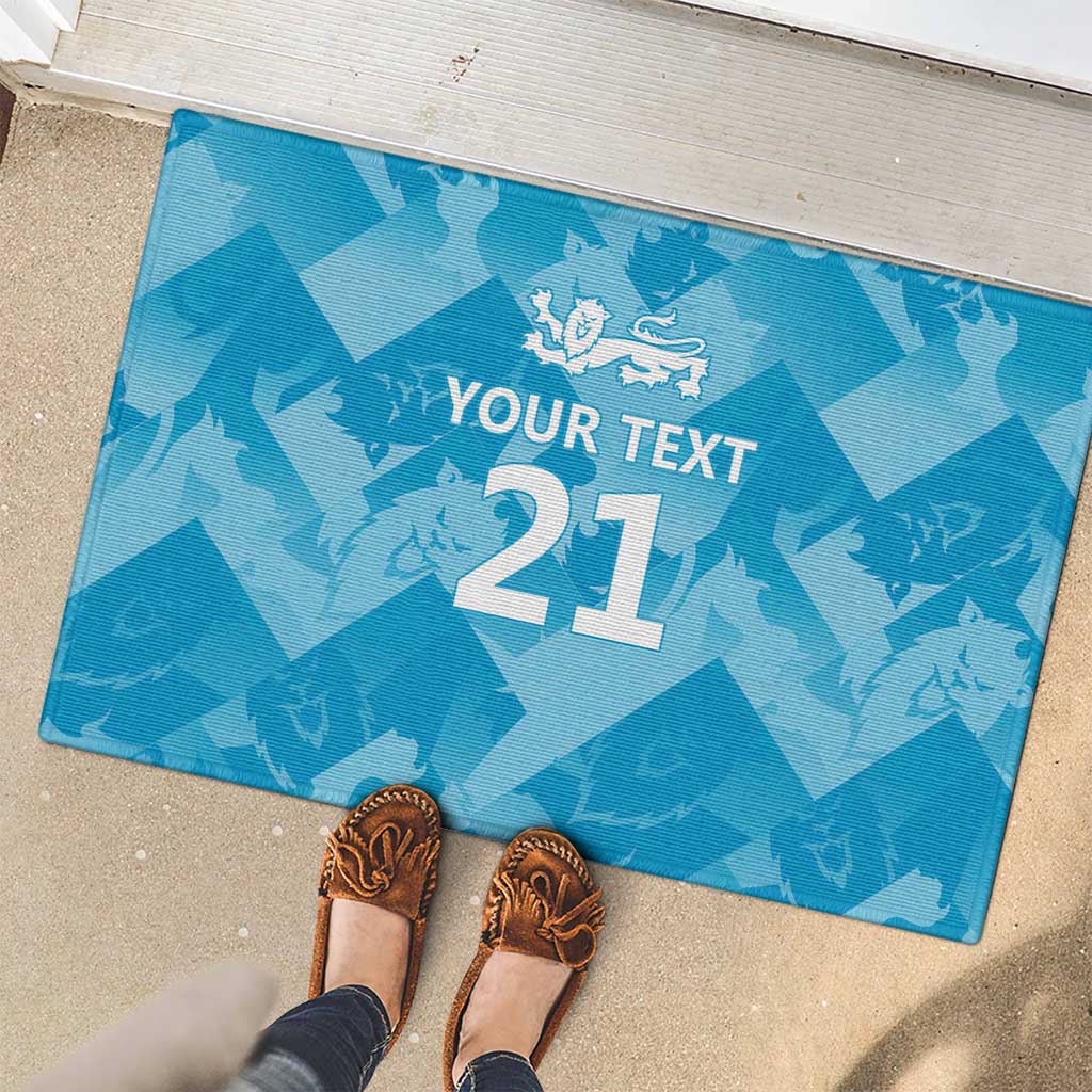 Blue rubber doormat with 'YOUR TEXT 21' and lion logo, with shoes standing on it.