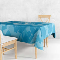 Blue lion-pattern tablecloth with overhanging edge on a wooden table and bench