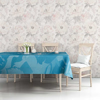 Blue lion-pattern tablecloth on a dining table with chairs against floral wallpaper