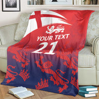 Red and dark blue cricket blanket with England flag, lion crest, and '21' on couch
