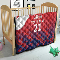 Red and navy quilt with Union Jack and lion crest, 'YOUR TEXT 21' on baby bed