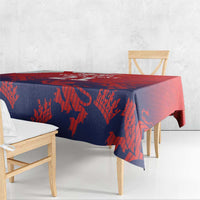 Red and navy tablecloth with flag-inspired lion pattern on wooden dining table