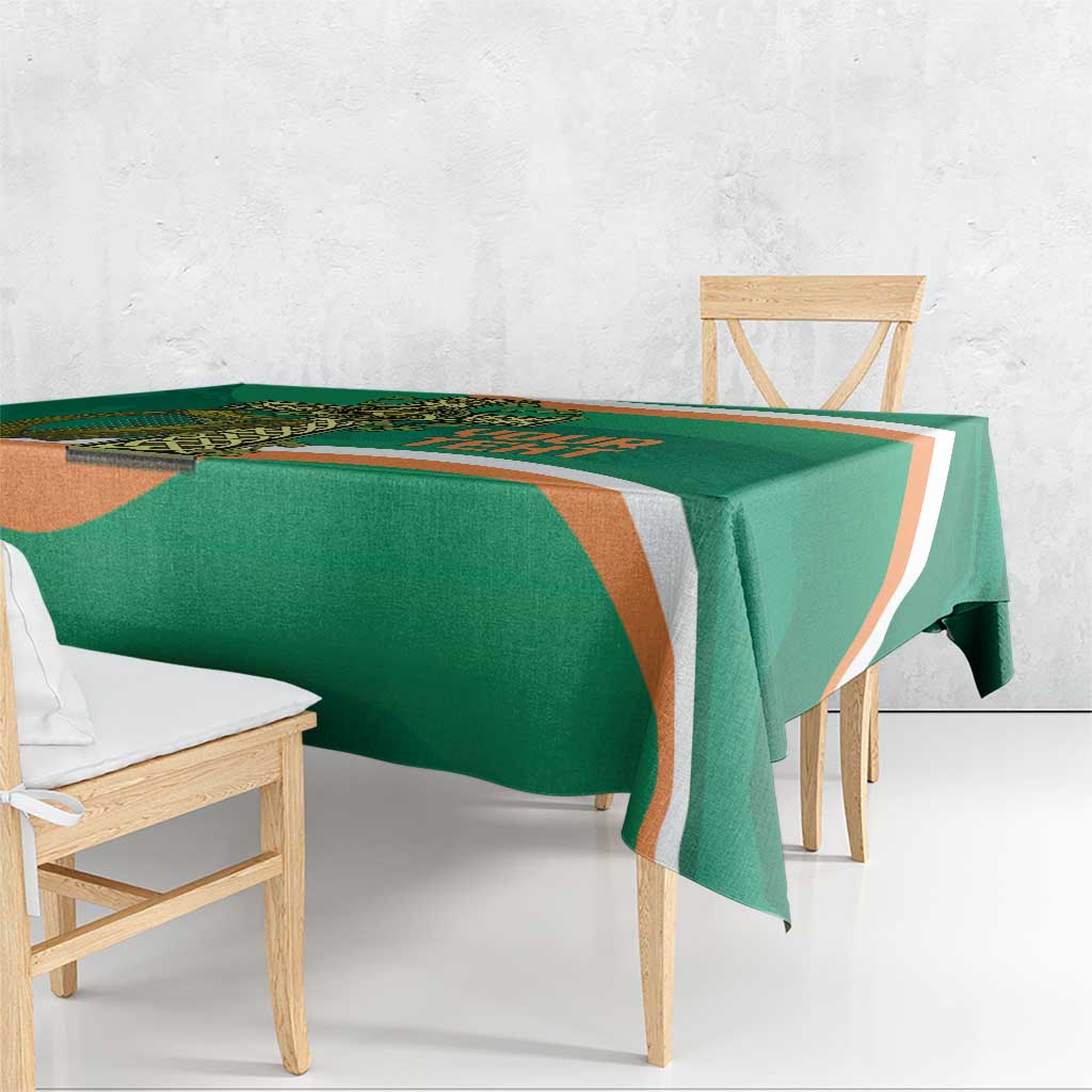 Green tablecloth draped over table with orange-and-white border stripe