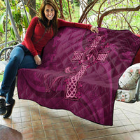 Maroon quilt with Celtic knot cross motif, draped over furniture with diamond quilting