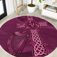 Maroon round rug with Celtic knot cross and harp design, textured surface