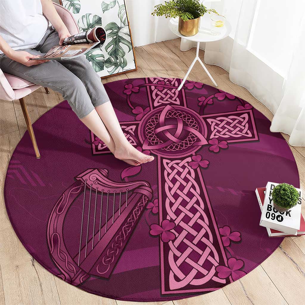 Maroon round rug with Celtic knot cross center, harp and leaf motifs