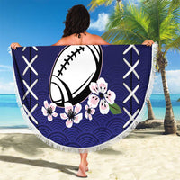 Round dark blue blanket with fringe, football and sakura pattern, held up outdoors