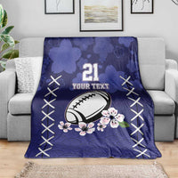 Blue rugby blanket on couch, number 21, football and pink blossoms, white X-stitch edging