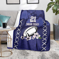 Blue rugby blanket draped on sofa, number 21, football graphic with floral blossoms and X trim