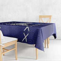 Blue tablecloth draped over rectangular table with repeating wave and white X design
