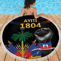 Round black beach blanket with fringe edge, AYITI 1804 emblem with palm tree and fist