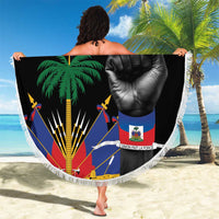 Round black beach blanket with fringe edge, palm and raised fist graphic held on sand