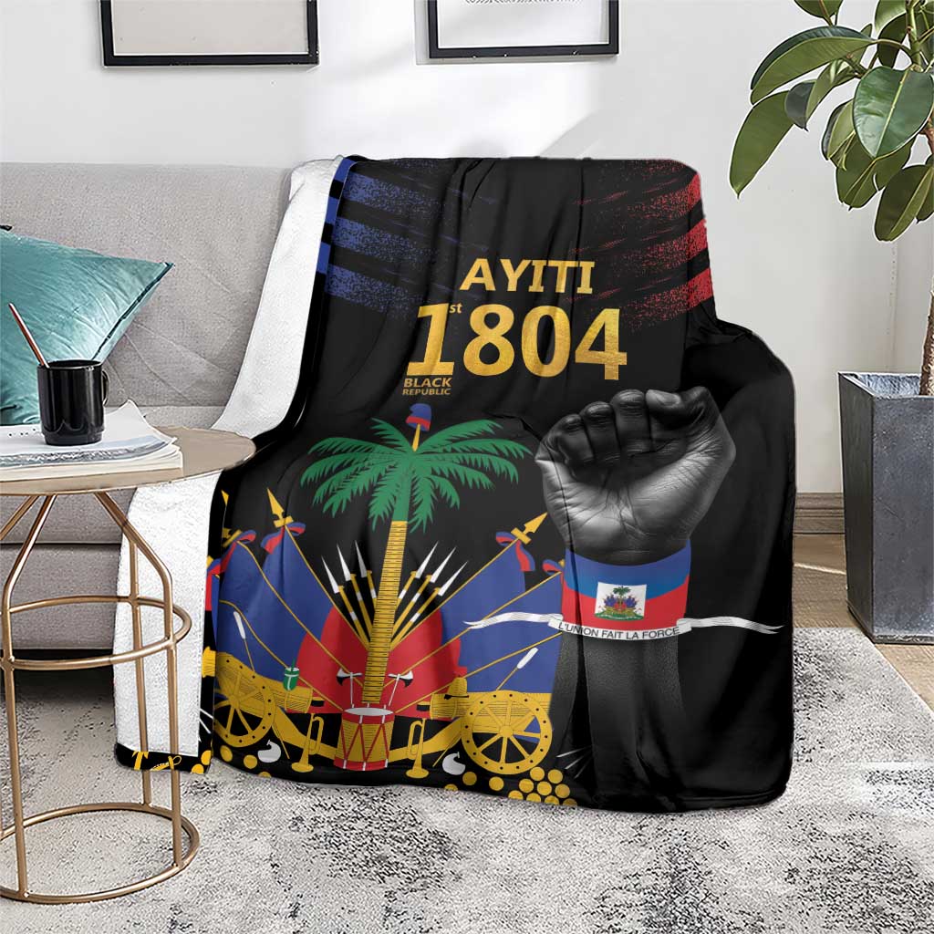 Black Haiti-themed blanket laid on living-room couch, featuring palm tree and raised fist