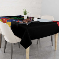 Black tablecloth with Haitian 1804 design and colorful emblem panel on tabletop