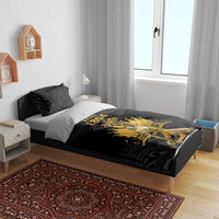 Black duvet and pillowcases with gold Ayiti 1804 print on a bed
