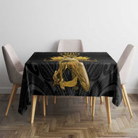 Black tablecloth with gold Polynesian motif covering a dining table and chairs