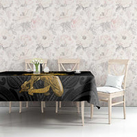 Black tablecloth with gold Polynesian pattern featuring a gold handholding figure