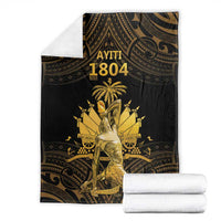 Black and gold Polynesian pattern blanket with 'AYITI 1804' design, folded with towels