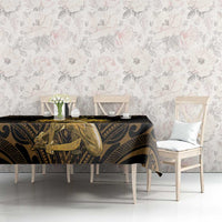 Black tablecloth with gold Polynesian motifs across dining table surface