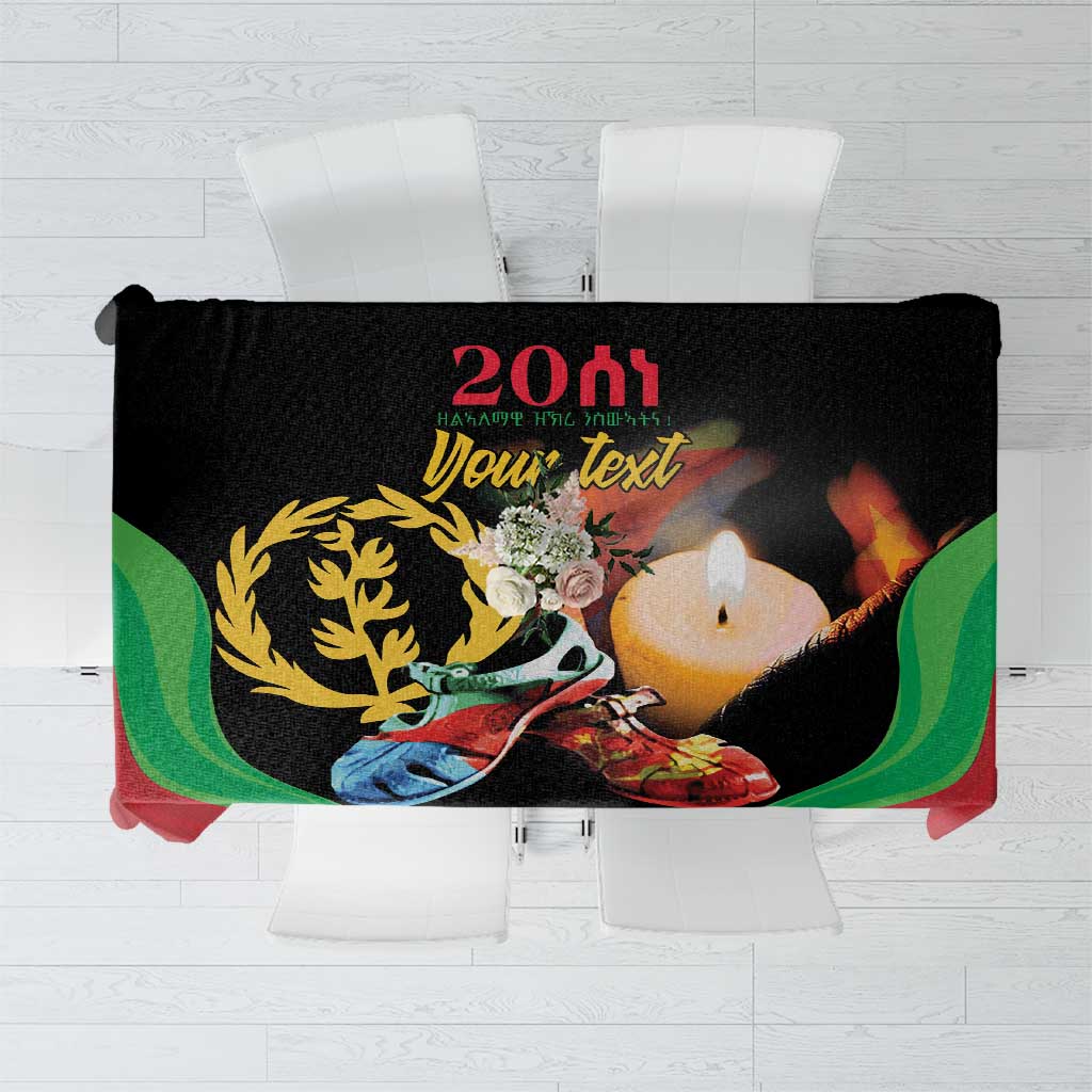 Black tablecloth with multicolor Eritrea-style graphic, candle and floral wreath