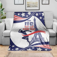 Sports blanket spread on a light sofa, featuring stars, patriotic ribbons, and tower art