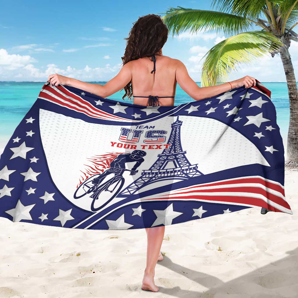 Blue, white, red star-pattern sarong held out wide, showing cyclist and Eiffel Tower print.
