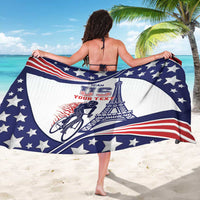 Blue, white, red star-pattern sarong held out wide, showing cyclist and Eiffel Tower print.