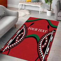 Red area rug with bold black tribal motifs, black/green accents, centered text