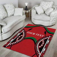 Red area rug with black and green tribal design and white outlined text