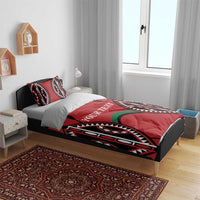 Red bedding set on bed with black, white, and green tribal graphics and “YOUR TEXT”.