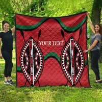 Red quilt blanket with large black/green geometric motif and custom text panel