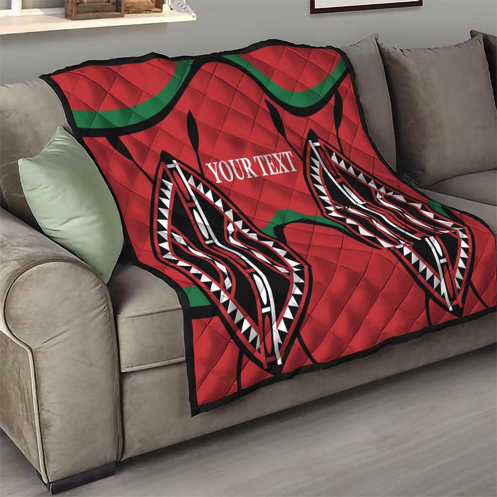 Red quilt blanket with black/green geometric pattern and centered custom text