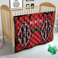 Red quilt blanket with diamond quilting, black/green emblem shapes, custom text