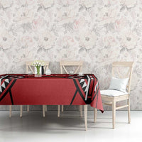 Red rugby-themed tablecloth on long dining table with black-and-green emblem pattern